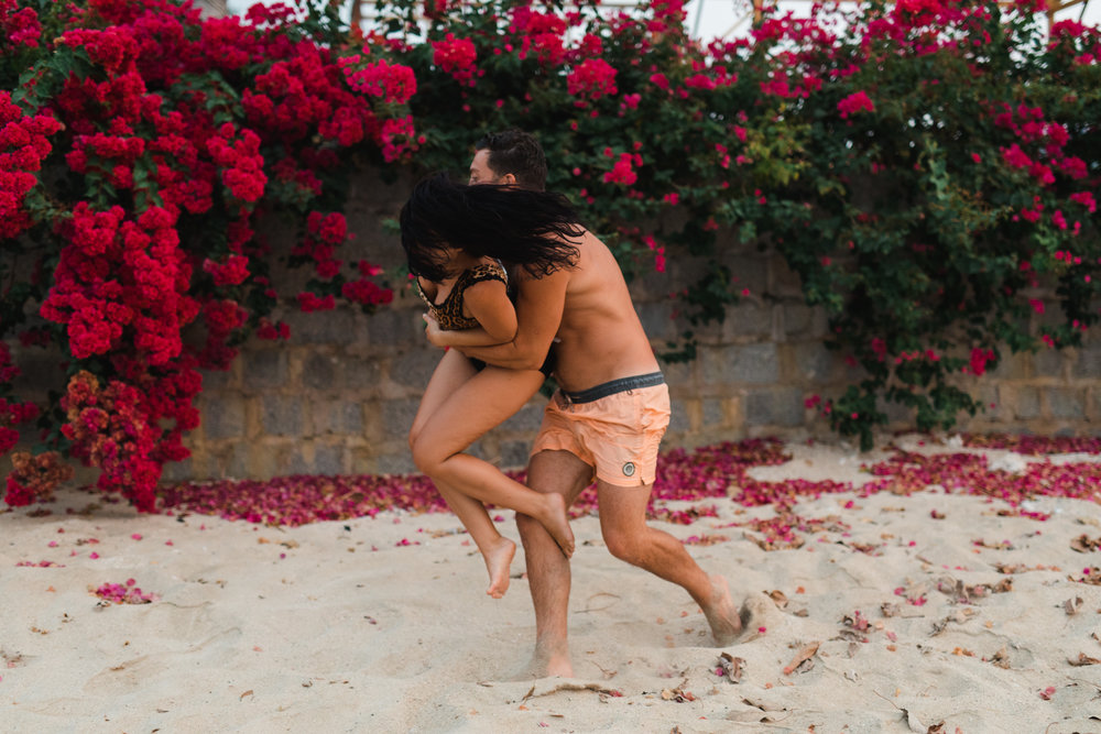 Playful couples photoshoot on the beach during sunrise