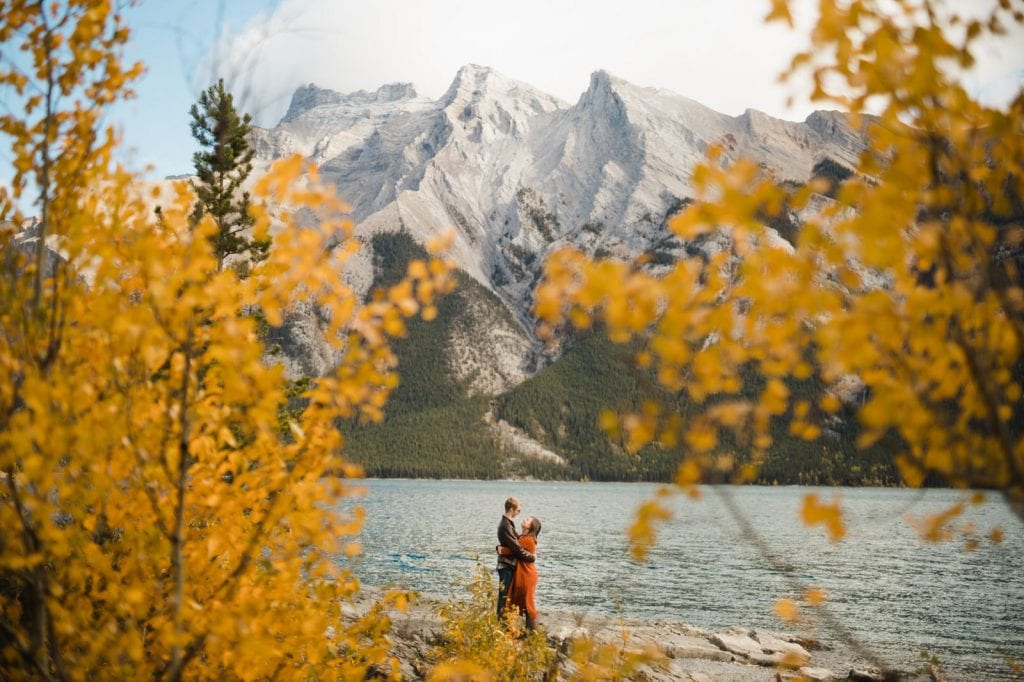 Lake Minnewanka mountains surrounded by yellow and orange leaves for couples non-traditional elopement
