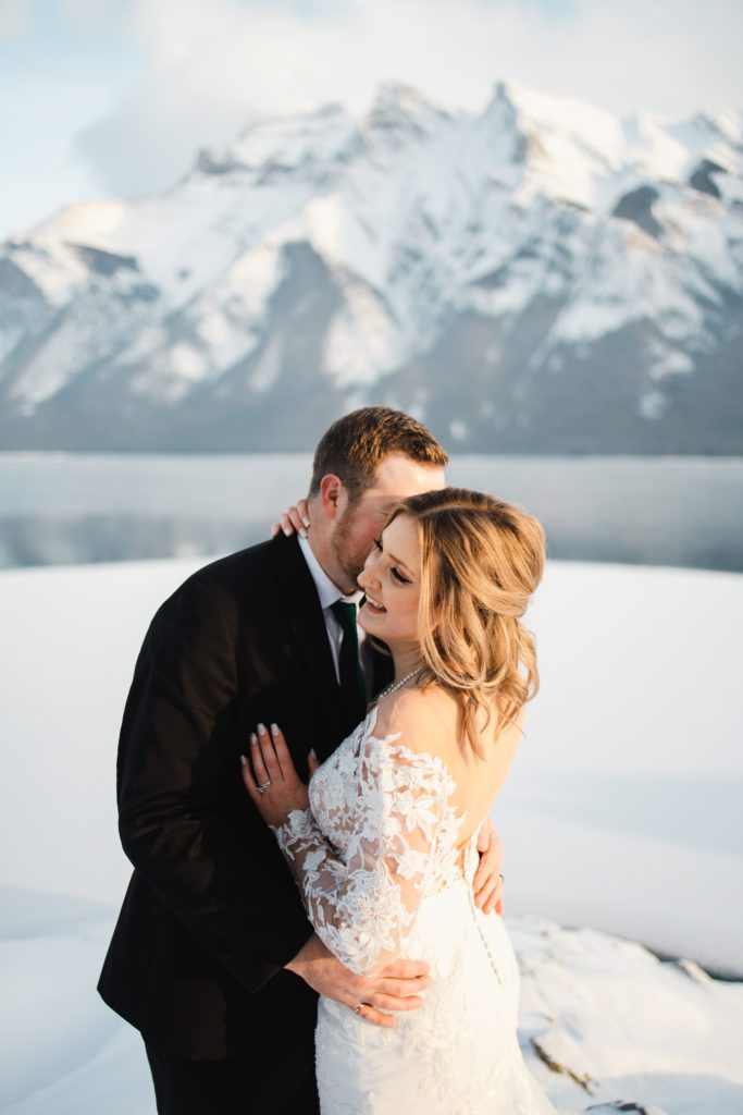 With a stunning lace wedding dress, this bride and groom created magical wedding portraits in Banff with the gorgeous mountains behind them
